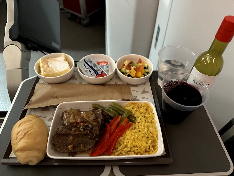 Iberia premium economy meal: Roasted beef loin in a dried mushroom and bacon sauce, served with yellow rice, chives, sautéed red pepper and green beans, served with accompaniments on a tray