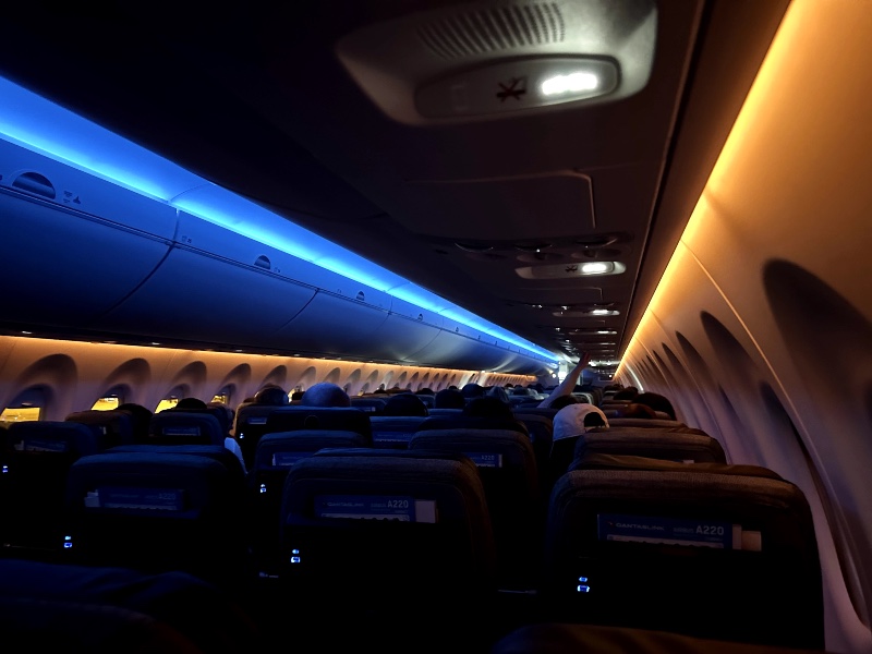 Orange and blue mood lighting in the QantasLink Airbus A220 cabin