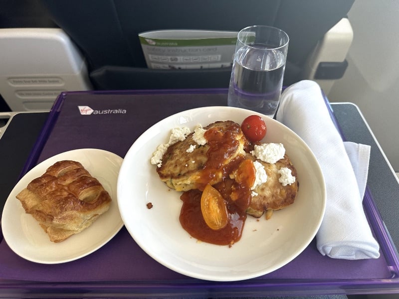 Virgin Australia business class breakfast - fritters with a pastry served on a tray with water