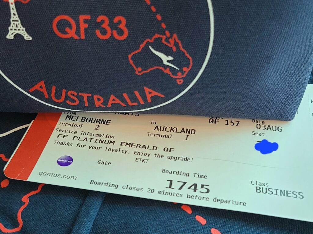 Qantas boarding pass with upgrade message and QF33 pyjamas