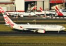 Virgin Australia A330 taxies past Qantas planes at Sydney Airport